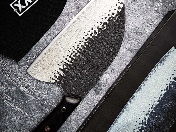 Hand-forged Damascus kitchen knife blade showing the layered pattern across the steel