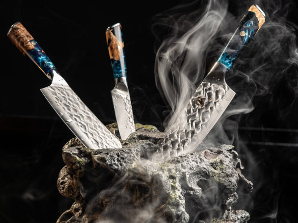 Hand-forged Damascus kitchen knives displayed on a wall in a modern kitchen