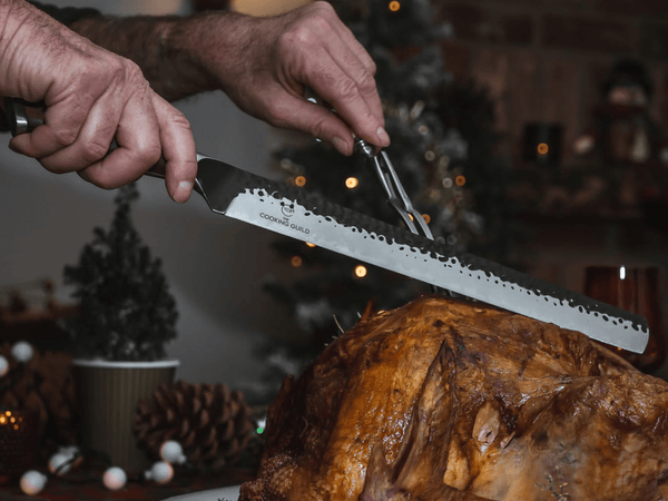 Turkey carving knife slicing a roast turkey at the table, a long hand-forged slicer