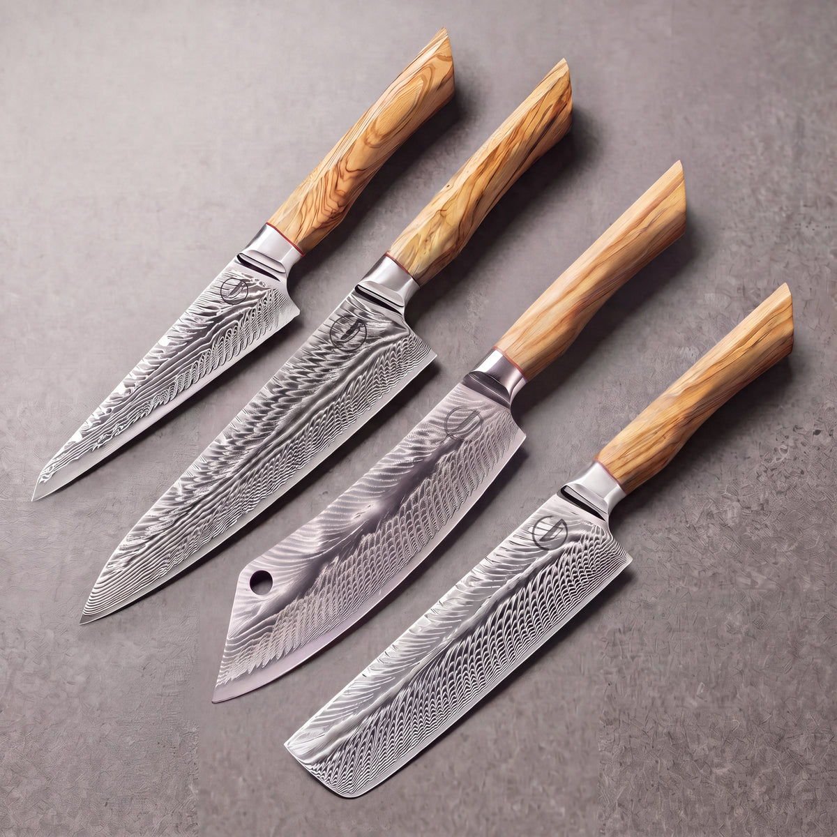 Feather Forge set: 8 inch chef, 8 inch cleaver, 7 inch nakiri and 6 inch utility knives laid on slate