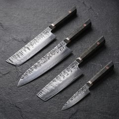 Bara Forge set: 9 inch kiritsuke, 9 inch gyuto, 7 inch nakiri and 5 inch paring knives laid on slate