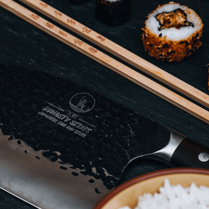 Serbian cleaver cutting through raw fish fillet