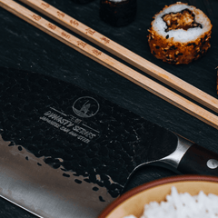 Serbian cleaver cutting through raw fish fillet